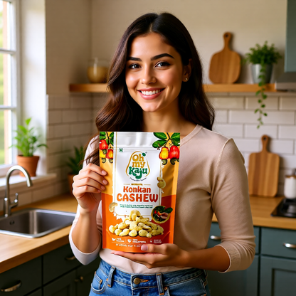 Woman holding a package of 'Oh My Kaju' Kanjani Cashew in a kitchen.