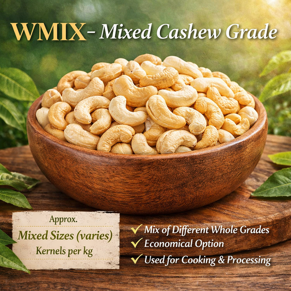 Wooden bowl filled with mixed cashew nuts on a wooden surface with green leaves in the background.